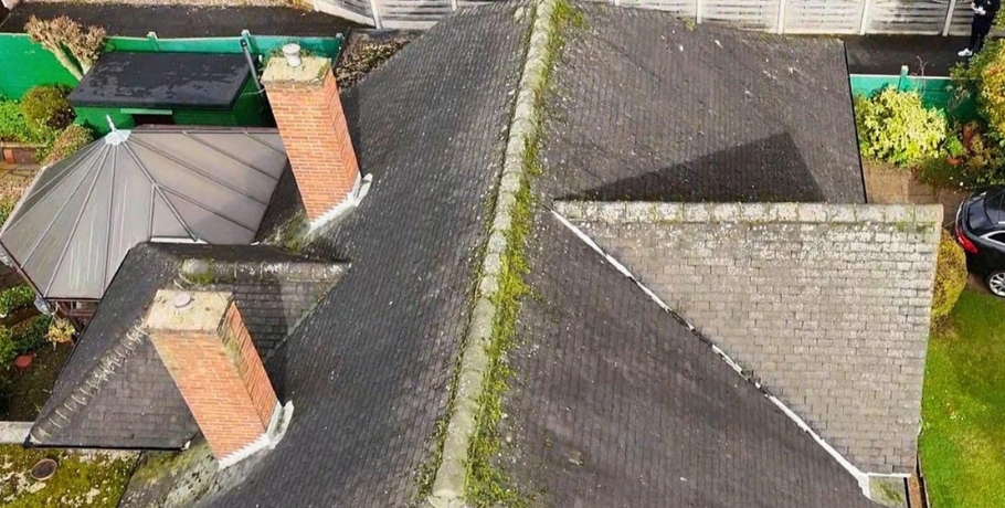 Overhead view of an old roof covered in moss and weather stains before professional roof restoration in Central Scotland