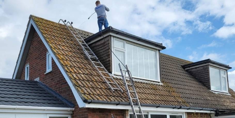 Roof covered in moss and stains being cleaned by a professional during a roof spraying preparation in Central Scotland